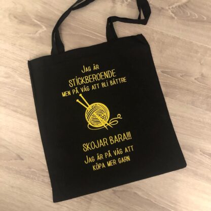 Tygkasse "stickberoende" gul text